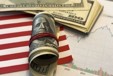 Financial trends concept image featuring U.S. currency placed on top of a financial chart with an upward trajectory. Financial trends concept image featuring U.S. currency placed on top of a financial chart with an upward trajectory.
