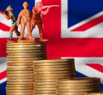 Concept illustration of the United Kingdom's defense budget, combining miniature toy soldiers with stacks of coins against the Union Jack flag. Concept illustration of the United Kingdom's defense budget, combining miniature toy soldiers with stacks of coins against the Union Jack flag.