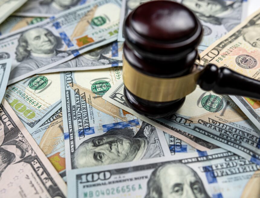 A gavel rests on a pile of U.S. currency, symbolizing the intersection of law and finance. A gavel rests on a pile of U.S. currency, symbolizing the intersection of law and finance.