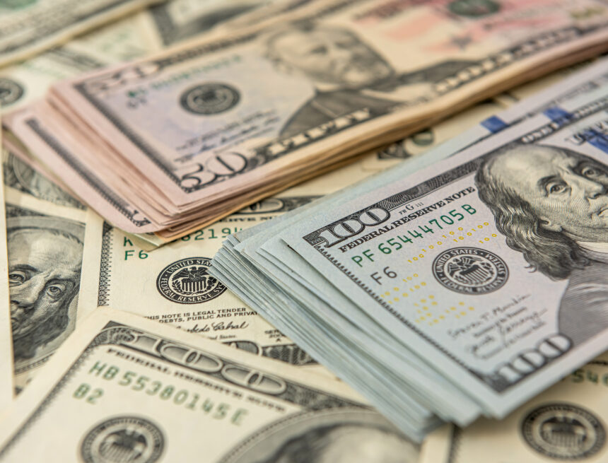 An image of a pile of assorted U.S. currency banknotes with prominent $100 notes and also a stack of $50 notes in the background. An image of a pile of assorted U.S. currency banknotes with prominent $100 notes and also a stack of $50 notes in the background.