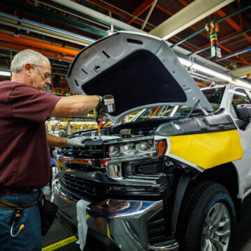 A Photo Of An Assembly Line At A General Motors (GM) Plant As Worker Ron Williams Is Attaching A Grill To A New Chevrolet Silverado Or GMC Sierra Pickup Truck.