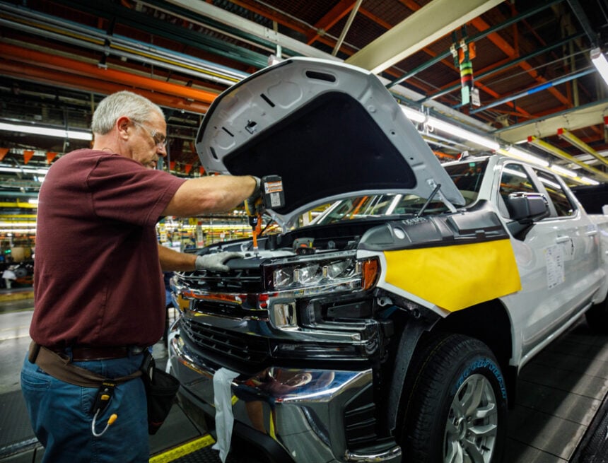 A Photo Of An Assembly Line At A General Motors (GM) Plant As Worker Ron Williams Is Attaching A Grill To A New Chevrolet Silverado Or GMC Sierra Pickup Truck. A Photo Of An Assembly Line At A General Motors (GM) Plant As Worker Ron Williams Is Attaching A Grill To A New Chevrolet Silverado Or GMC Sierra Pickup Truck.