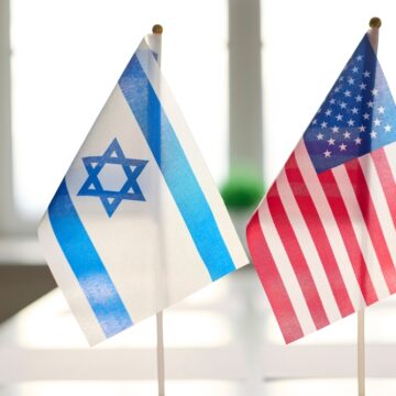 Miniature Israeli And U.S. Desk Flags Positioned Side-by-Side On A Table