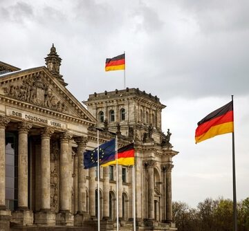 The German flag waves in front of the Reichstag building in Berlin, which serves as the seat of the German Parliament (Bundestag).
