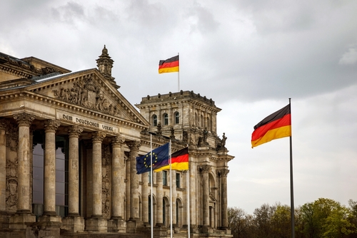 The German flag waves in front of the Reichstag building in Berlin, which serves as the seat of the German Parliament (Bundestag).