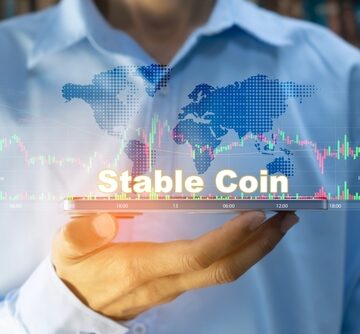 Businessman holding a tablet with the words "Stable Coin" floating amid various charts and graphs. Businessman holding a tablet with the words "Stable Coin" floating amid various charts and graphs.