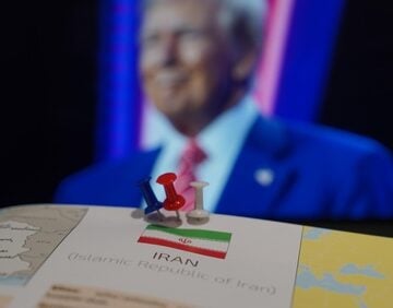 A map prominently displaying Iran with pushpins, positioned in front of a blurred image of Donald Trump in the background. A map prominently displaying Iran with pushpins, positioned in front of a blurred image of Donald Trump in the background.