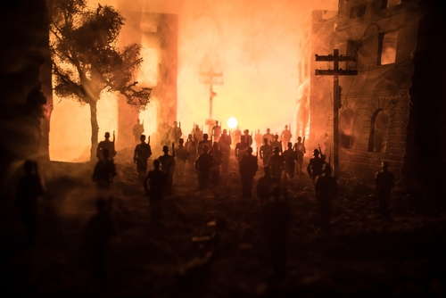 An apocalyptic view of a city featuring silhouettes of soldiers marching against a background is filled with fire, smoke, and a bright explosion.