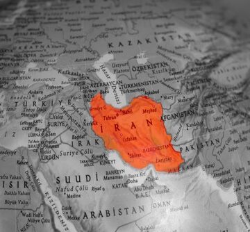 A black-and-white globe with Iran highlighted in red.
