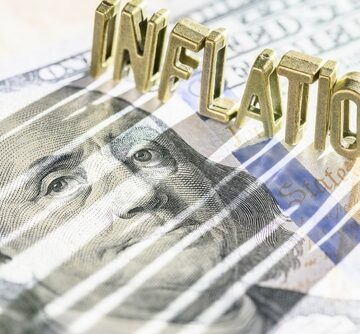Inflation concept featuring stylized letters spelling out the word "Inflation" over a U.S. $100 dollar bill.