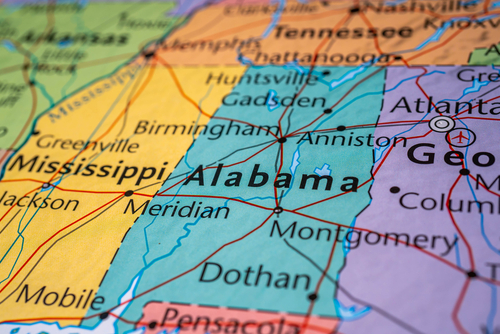 Close-up of a colorful map highlighting the state of Alabama bordered by Mississippi to the west, Tennessee to the north, and Georgia to the east.