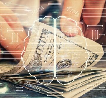 Conceptual image showing the intersection of artificial intelligence and finance depicted by a hologram of a human brain overlaid with circuit patterns and U.S. currency in the background.