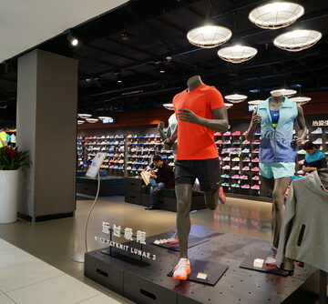 A Nike retail store, located in Hangzhou, China, showing an interior featuring mannequins wearing athletic apparel from the brand's running collection.