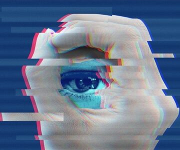 A digital collage of close-up of an eye framed by a hand which is frequently used in media to symbolize surveillance and the concept of "Big Brother" watching.