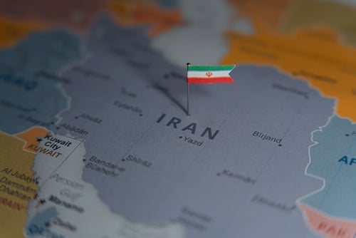 A political map of the Middle East region with a small flag of Iran pinned directly over the country.