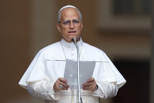 Pope Leo XIV addressing the public from a lectern in Castel Gandolfo, Italy, the traditional summer residence of the Pope.