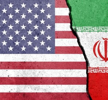 The American flag on the left and the Iranian flag on the right, painted against a cracked wall. The American flag on the left and the Iranian flag on the right, painted against a cracked wall.