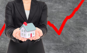 Real,Estate,Housing,Market,Bubble,Inflation.,Realtor,Holding,Miniature,House An illustration of a person holding a small house model against a background with a red line graph.