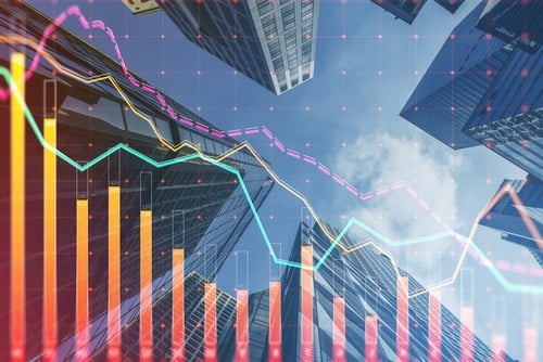 Concept image of financial trends and commercial real estate displaying a financial stock market chart overlaid on a digital background of office buildings.