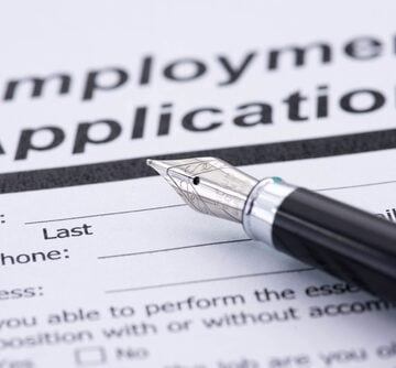 A,Pen,And,An,Employment,Contract A job application form with a modern quill pen on top.