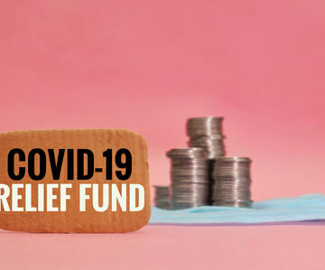 COVID-19 relief fund concept featuring coins and a protective mask.