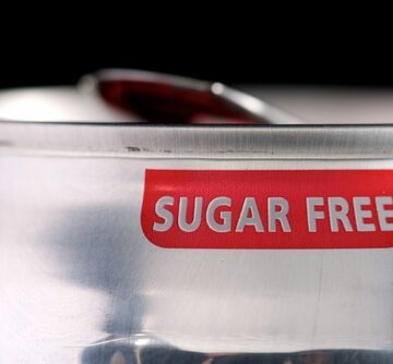 A close-up of an aluminum beverage can with a prominent red and white "SUGAR FREE" label.