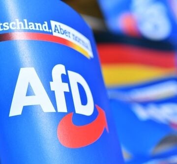 The image displays marketing materials for the Alternative for Germany (AfD) party, featuring their branding and campaign slogan. The image displays marketing materials for the Alternative for Germany (AfD) party, featuring their branding and campaign slogan.