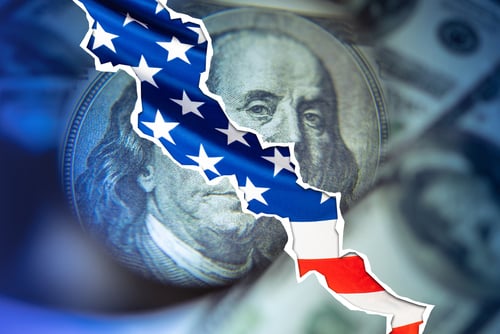 Concept illustration of economic instability showing a torn $100 bill with a "crack" through the bill and the U.S. flag filling the gap.