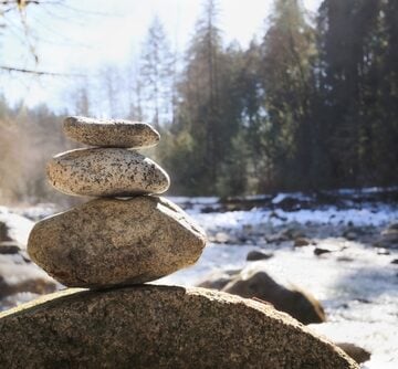 Rock,Pile,Or,Stack,In,Front,Of,Defocused,River,And YOU DESERVE A BEAUTIFUL LIFE (Part I) – On Presence, Flow, and the Courage to Be Yourself