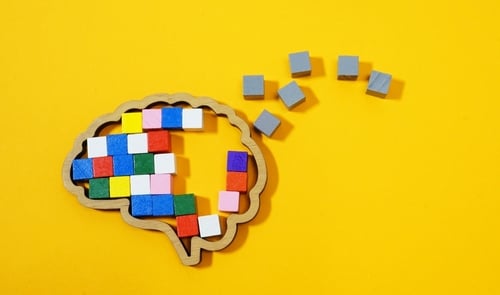 Brain,Made,Of,Colorful,Blocks,Breaking,Into,Gray,Pieces.,Mental A brain shape made of colorful blocks representing the complexity of thought and memory with gray pieces falling away symbolizing cognitive impairment.