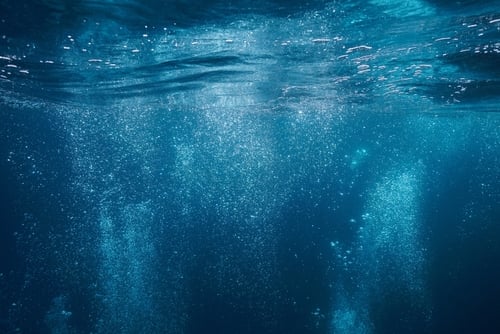 Air,Bubbles,Rise,To,Water,Surface,Underwater,In,The,Mediterranean Underwater air bubbles rise to the surface in a deep blue sea.