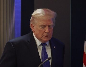 This image shows Donald Trump speaking at a press conference at the White House on February 20, 2026, shortly after a Supreme Court ruling regarding his tariff policies.