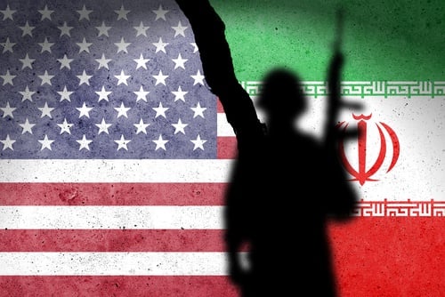 Flag,Of,Usa,And,Iran,Painted,On,A,Concrete,Wall A silhouette of a soldier against the flags of the United States and Iran separated by a large crack.