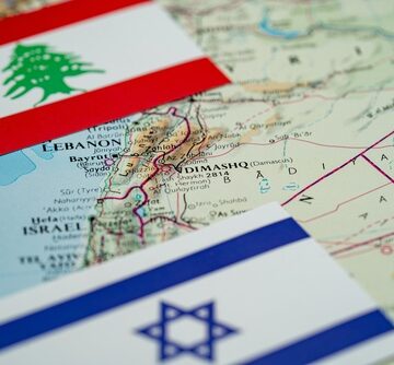 Close,Up,Of,Lebanon,And,Israel,Flags,On,Map,Of The flags of Lebanon and Israel positioned over a map of the region, highlighting their close geographical proximity and shared border.