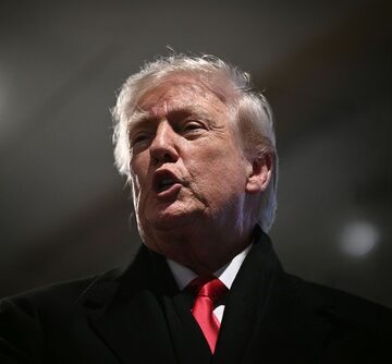 Donald Trump speaking in front of spotlights.