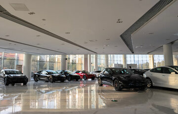 A Tesla showroom likely featuring a variety of electric vehicles, including the Model 3 and Model Y.