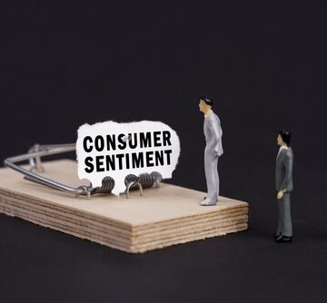 Business,Trap,,Crisis,Concept.,Figures,Of,Businessmen,Stand,Near,A Miniature businessmen cautiously approaching a mousetrap baited with "Consumer Sentiment," illustrating the current economic anxiety as major sentiment indicators reach historic lows.