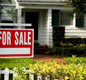 For,Sale,Sign,Outside,A,Family,House A red and white "FOR SALE" sign is posted in front of a residential house.