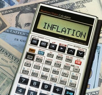 This image displays a Sharp EL-733A financial calculator placed on top of U.S. currency.