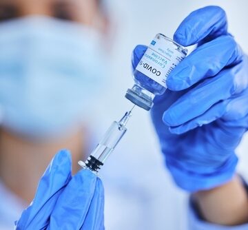 A healthcare worker prepares a syringe with a COVID-19 vaccine.