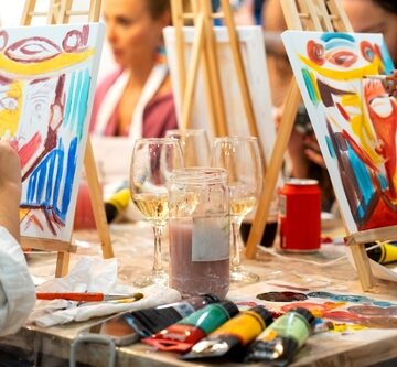 A paint and sip social event, a popular activity combining painting instruction with drinking beverages like wine.