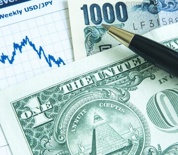 Close-up of a weekly trading graph, a U.S. one-dollar bill, and a Japanese 1000 yen note.