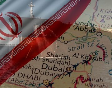 Concept image shows overlay of the Iranian national flag, and a freighter, onto a regional map showing critical maritime and trade hubs, including Bandar Abbas, Dubai, and Sharjah. Concept image shows overlay of the Iranian national flag, and a freighter, onto a regional map showing critical maritime and trade hubs, including Bandar Abbas, Dubai, and Sharjah.
