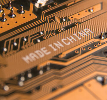 Macro,Image,Of,A,Motherboard,With,The,Inscription,"made,In A close-up of a printed circuit board with "MADE IN CHINA" printed on it.