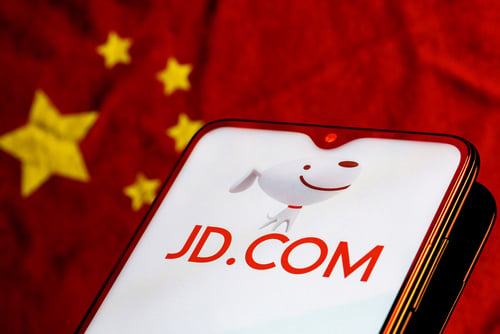 The JD.com logo, a major Chinese e-commerce company, on a smartphone with the flag of China in the background. The JD.com logo, a major Chinese e-commerce company, on a smartphone with the flag of China in the background.