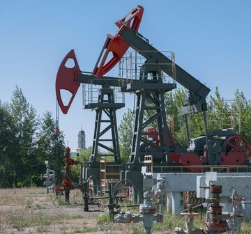 Oil,Pumpjack,With,Wellhead,Valves,At,Active,Onshore,Oil,Field Oil pumpjacks with well valves operating in an onshore oil field.