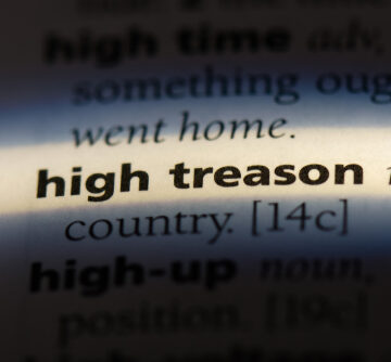 A close-up view of the dictionary definition for the term "high treason".
