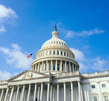 United,States,Capitol,Building,With,American,Flag,Over,Blue,Sky The United States Capitol Building in Washington, D.C., which serves as the meeting place for the U.S. Congress.