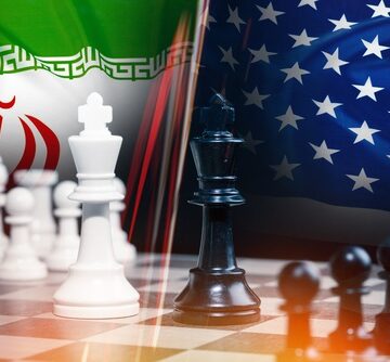 An overlay of a chess game, with kings prominently positioned, against the Iranian and U.S. flags.