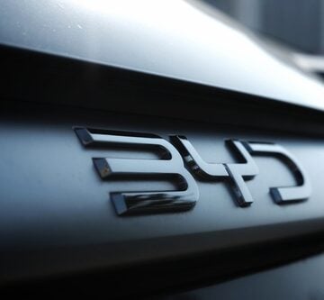 Close-up of the prominent, dark-finished logo of BYD, a major Chinese manufacturer of electric and plug-in hybrid vehicles.